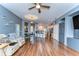Open layout living room area with wood floors, ceiling fan, and access to the kitchen at 11427 Laurel Brook Ct, Riverview, FL 33569