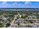 Stunning aerial shot of the property, surrounded by lush greenery and a beautiful lake in the background at 11546 Leisure W Ln, Largo, FL 33773