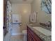 The bathroom showcases a vanity with granite countertops, a sink, and a mirror, next to the shower at 11546 Leisure W Ln, Largo, FL 33773