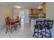 Open dining area featuring a wooden table, tile floors, and seamless transition to the kitchen, perfect for modern living at 11546 Leisure W Ln, Largo, FL 33773