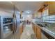 This kitchen offers stainless steel appliances, tile flooring, and wooden cabinets and an adjacent dining area at 11546 Leisure W Ln, Largo, FL 33773