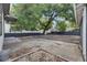 Large backyard featuring mature trees, gravel landscaping, concrete slab, and partial fencing at 1208 E 18Th Ave, Tampa, FL 33605