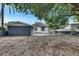 Spacious backyard with detached structure, mature trees, gravel landscaping, and partial fencing at 1208 E 18Th Ave, Tampa, FL 33605