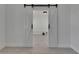Stylish white barn doors on a track, open to reveal a room with light wood flooring and modern light fixture at 1208 E 18Th Ave, Tampa, FL 33605
