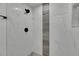 This shower features attractive white and grey tiles and black fixtures at 1208 E 18Th Ave, Tampa, FL 33605