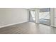 Bedroom with sliding glass door to the pool area, neutral paint, and grey floors at 12221 Saddle Strap Row, Hudson, FL 34667