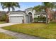 Well-maintained single-story home featuring a manicured lawn and attached two-car garage in a suburban neighborhood at 12531 Blazing Star Dr, Tampa, FL 33626