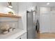Bright kitchen featuring stainless steel appliances, white cabinets, and a floating wooden shelf at 12531 Blazing Star Dr, Tampa, FL 33626