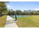 Outdoor tennis court surrounded by lush greenery and a paved walkway at 12531 Blazing Star Dr, Tampa, FL 33626