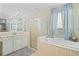 Bathroom showcasing a luxurious bathtub, glass-enclosed shower, and elegant tile work at 13135 Plantation Ter, Seminole, FL 33776