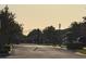 View of the community gate leading into a neighborhood surrounded by trees, with lampposts on either side at 13135 Plantation Ter, Seminole, FL 33776