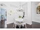 Bright dining area featuring dark wood floors, a white table, and stylish chandelier at 13135 Plantation Ter, Seminole, FL 33776