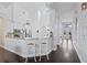 Open kitchen with white cabinetry, a bar area, and hardwood floors throughout at 13135 Plantation Ter, Seminole, FL 33776