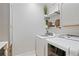 Bright laundry room featuring a modern washer and dryer set, complemented by decorative shelves and cabinetry at 13135 Plantation Ter, Seminole, FL 33776