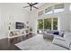 Bright living room featuring dark hardwood floors, a large television, and sliding doors to the pool at 13135 Plantation Ter, Seminole, FL 33776