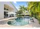 Resort-style pool with a fountain, lush landscaping, and an umbrella-covered seating area at 13135 Plantation Ter, Seminole, FL 33776