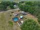 Lovely aerial shot of the property with a screened-in pool and various outbuildings at 13208 Sydney Rd, Dover, FL 33527