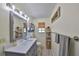 Well-lit bathroom featuring a gray vanity with modern fixtures and a decorative shelf at 13208 Sydney Rd, Dover, FL 33527