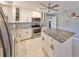 Modern kitchen features white cabinets, stainless steel appliances, and granite countertops at 13208 Sydney Rd, Dover, FL 33527