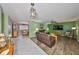 Open-concept living room with a ceiling fan, view into the dining room, and tiled floors at 13208 Sydney Rd, Dover, FL 33527