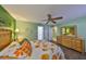 Bright main bedroom includes a ceiling fan, dresser, and adjacent bathroom at 13208 Sydney Rd, Dover, FL 33527