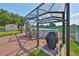 Above ground caged pool surrounded by brick patio, landscaping, and grill at 13208 Sydney Rd, Dover, FL 33527
