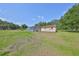 Overview of grassy acreage with building and caged pool at 13208 Sydney Rd, Dover, FL 33527
