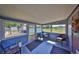 Enclosed sunroom featuring blue walls, tile floors and many windows overlooking the backyard and caged pool at 13208 Sydney Rd, Dover, FL 33527