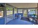 Enclosed sunroom featuring blue walls, tile floors and many windows overlooking the landscaped backyard at 13208 Sydney Rd, Dover, FL 33527