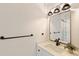 Modern bathroom with black fixtures, a white vanity, and a decorative mirror with views of the shower at 1401 49Th N St, St Petersburg, FL 33710