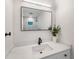 Bright bathroom features a modern vanity, black faucet, and a square mirror with a shower view at 1401 49Th N St, St Petersburg, FL 33710