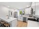 Stylish kitchen boasts white cabinets, stainless steel appliances, a sleek countertop, and hardwood floors at 1401 49Th N St, St Petersburg, FL 33710