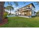 A stunning view of the home's exterior highlighting the spacious backyard, covered patio, and pristine landscaping at 1542 Bayshore Blvd, Dunedin, FL 34698