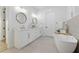 Elegant bathroom with double sink vanity, soaking tub and bright natural lighting from the window at 1542 Bayshore Blvd, Dunedin, FL 34698