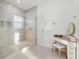 Bright bathroom featuring a glass shower with vanity and a white bench at 1542 Bayshore Blvd, Dunedin, FL 34698