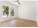 Bright bedroom with hardwood floors and large windows providing natural light and a view of outdoor greenery at 1542 Bayshore Blvd, Dunedin, FL 34698