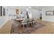 Bright dining area with modern table, chairs, area rug, and access to a kitchen with white cabinetry and marble countertops at 1542 Bayshore Blvd, Dunedin, FL 34698