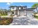 The home has a manicured lawn and a three car garage with a grey and white modern exterior design at 1542 Bayshore Blvd, Dunedin, FL 34698