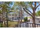 A view of the house on the water with a balcony, as seen through the trees at 1542 Bayshore Blvd, Dunedin, FL 34698