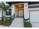 Elegant front entrance with double doors, custom planters, covered entryway and stone steps at 1542 Bayshore Blvd, Dunedin, FL 34698