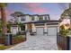 Beautiful two-story home with black framed windows, a three-car garage, and custom gray paved driveway at 1542 Bayshore Blvd, Dunedin, FL 34698