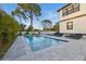 A refreshing rectangular pool surrounded by a spacious patio and lush greenery, perfect for outdoor relaxation at 1542 Bayshore Blvd, Dunedin, FL 34698