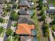 Aerial view of a house with orange roof with a screened-in pool and neighboring houses at 15630 N Himes Ave, Tampa, FL 33618