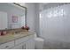 Charming bathroom features white cabinets, marble countertop, and decorative shower curtain at 15630 N Himes Ave, Tampa, FL 33618