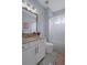 Bathroom with white cabinets, marble countertop, framed mirror, decorative light fixture, and tiled floors at 15630 N Himes Ave, Tampa, FL 33618