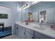 Bathroom featuring a large mirror, double vanity with gray cabinets, and a view into an adjacent room at 15630 N Himes Ave, Tampa, FL 33618