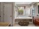 Luxurious bathroom features a deep soaking tub with stone accents, a large window, and stylish marble tile at 15630 N Himes Ave, Tampa, FL 33618