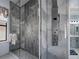 Modern bathroom featuring a glass enclosed shower with gray accent wall and shower panel at 15630 N Himes Ave, Tampa, FL 33618