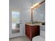 Bathroom with a wood vanity with a marble countertop, modern fixtures and a door with obscured glass at 15630 N Himes Ave, Tampa, FL 33618