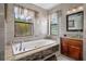 Elegant bathroom features a soaking tub, dual windows with sheer curtains, and a rich wood vanity at 15630 N Himes Ave, Tampa, FL 33618